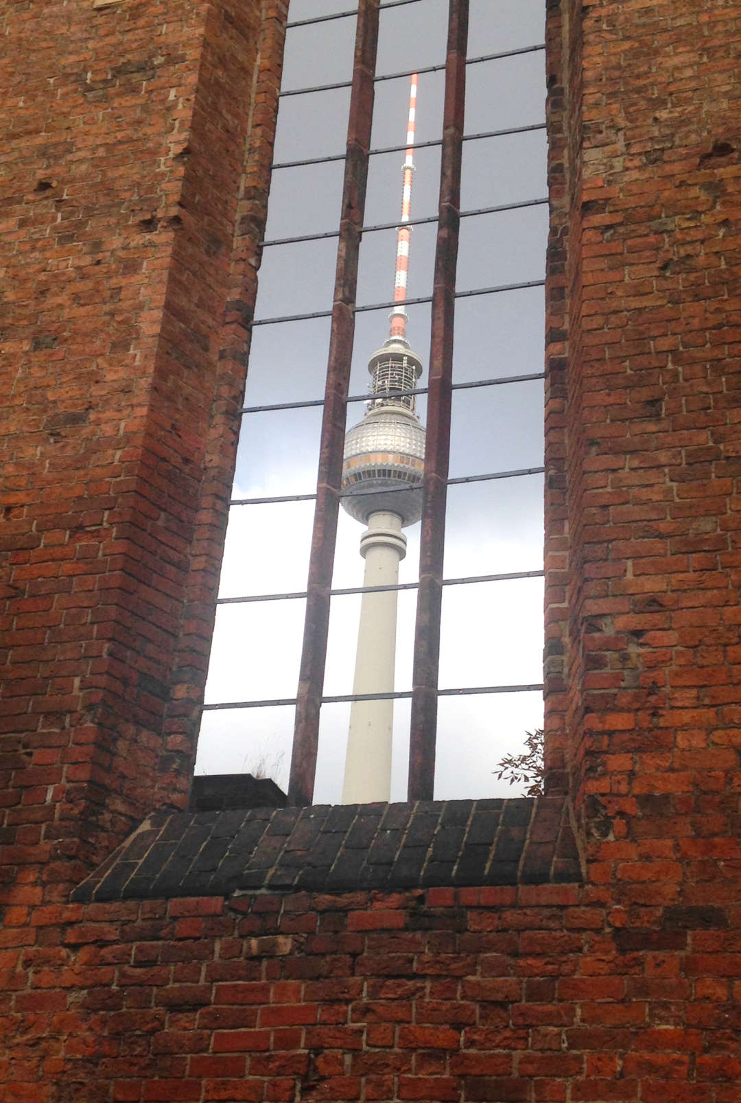 Der Fernsehturm wird in einem Fenster der Marienkirche, am Berliner Alexanderplatz, gespiegelt.